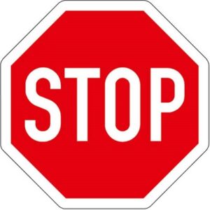 Achtkantiges rotes Verkehrsschild mit weißem Rahmen und der Aufschrift "STOP". bodenmarkierung-profishop.de